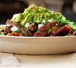 Steak burrito bowl on a wood board.